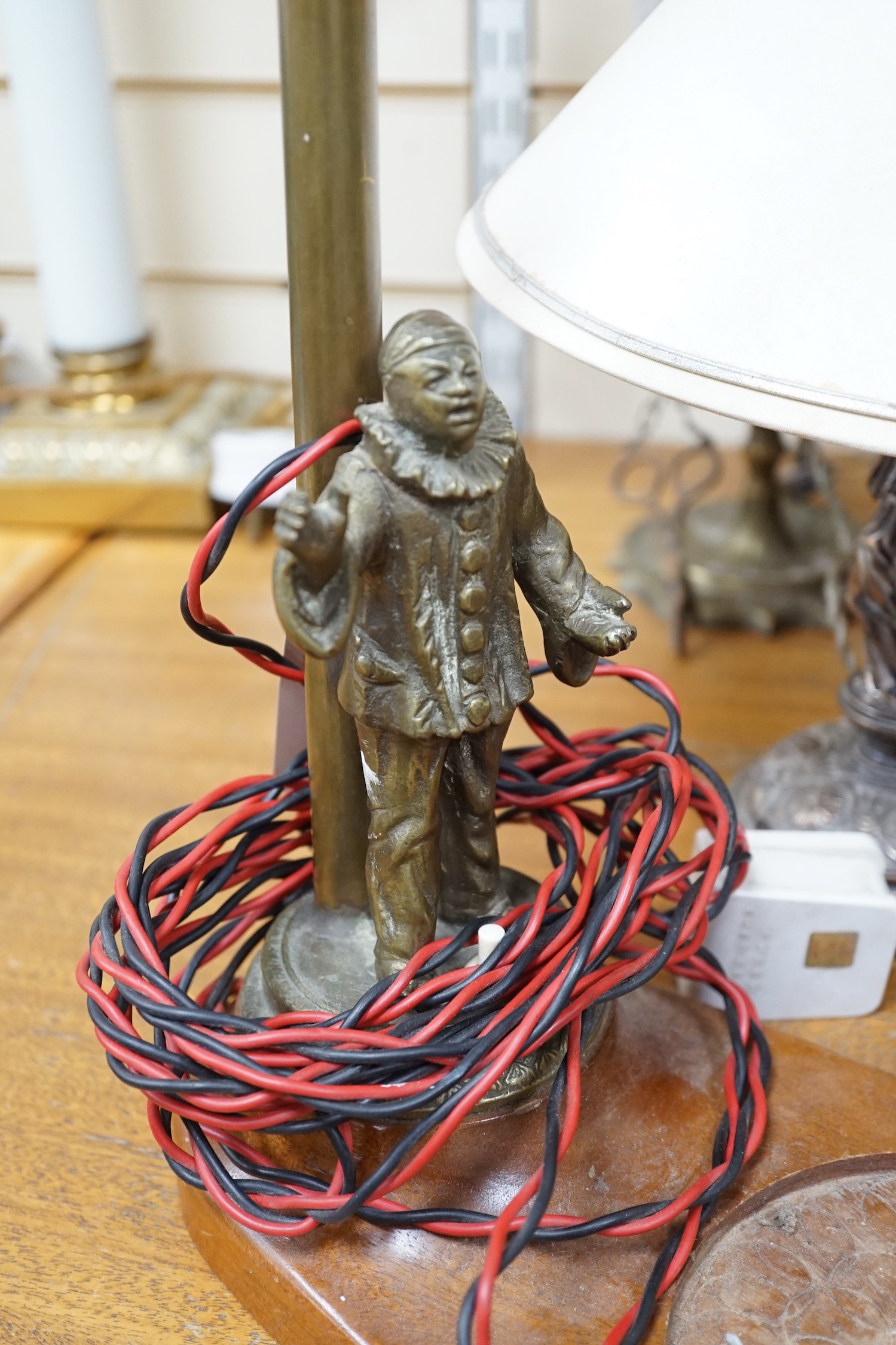 A Sheffield plated figural table lamp, a brass figural ‘Pierrot’ table lamp and An Eastern brass converted lamp with attached snuffer